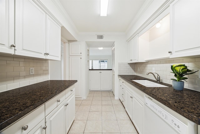 kitchen featuring dishwasher, dark stone counters, sink, white cabinetry, and tasteful backsplash