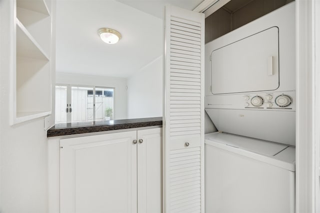 washroom featuring stacked washer / drying machine