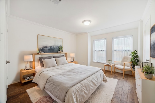 bedroom featuring crown molding and dark hardwood / wood-style flooring