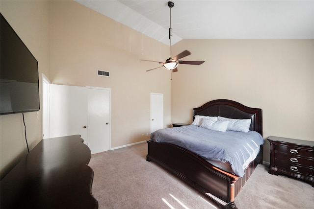 carpeted bedroom with ceiling fan and high vaulted ceiling