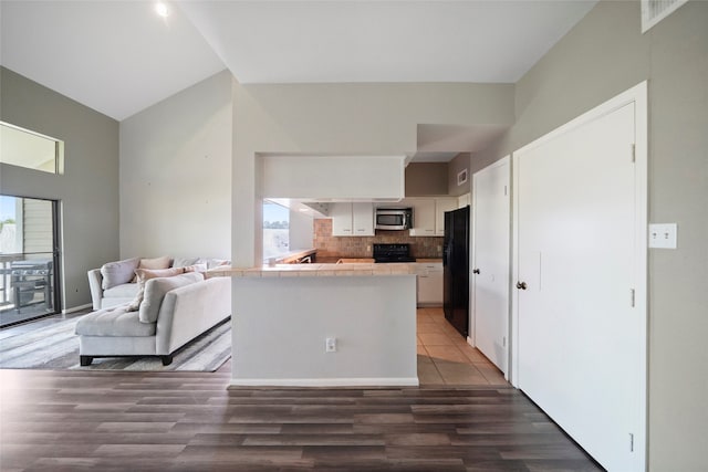 kitchen with white cabinets, a healthy amount of sunlight, dark wood-type flooring, and black appliances