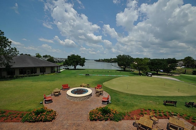 surrounding community with a yard, a water view, and an outdoor fire pit