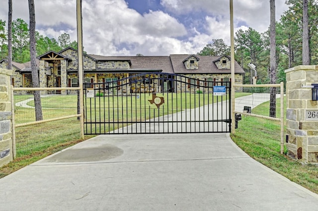 view of gate with a yard