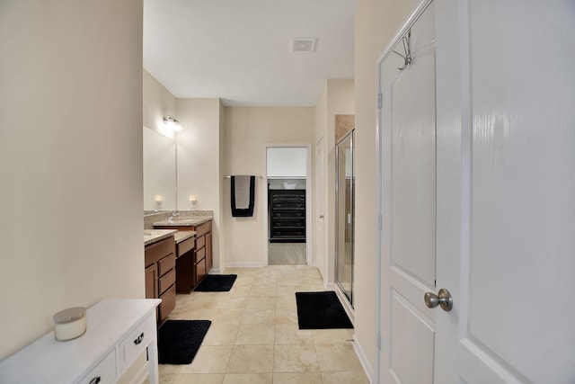 bathroom with tile patterned flooring, vanity, and a shower with door