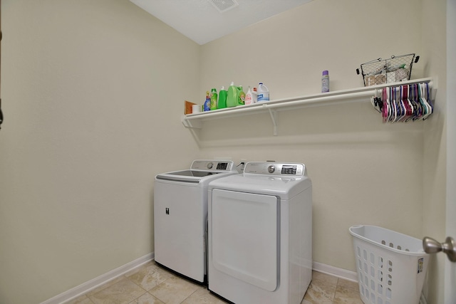 clothes washing area with independent washer and dryer and light tile patterned flooring