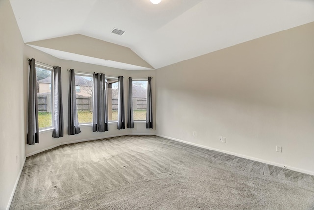 carpeted spare room with lofted ceiling