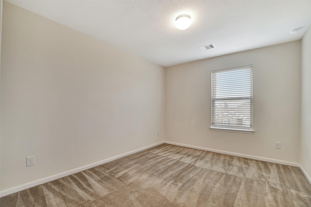 carpeted spare room featuring a textured ceiling