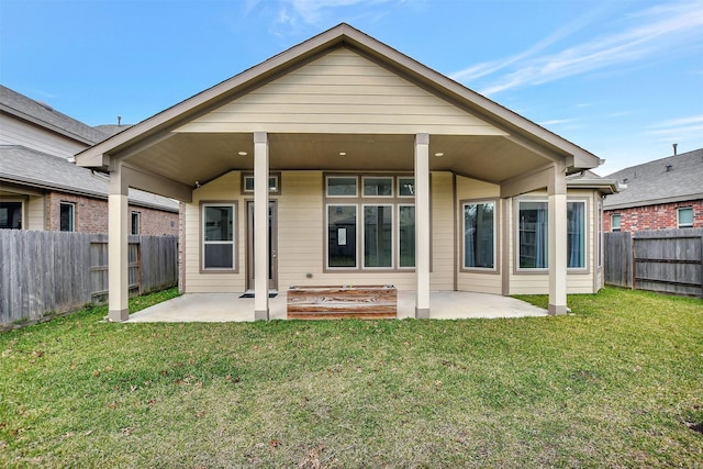 back of house with a patio and a lawn