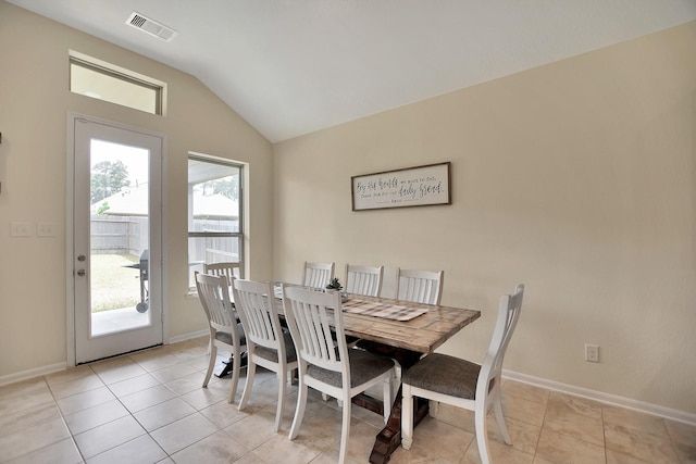 dining room with light tile patterned floors and lofted ceiling