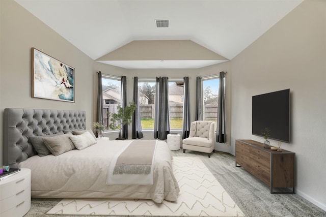 carpeted bedroom featuring lofted ceiling and multiple windows