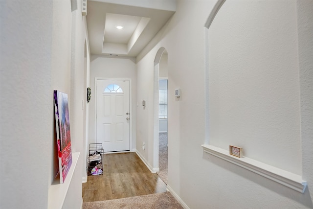 doorway featuring light hardwood / wood-style flooring and a tray ceiling