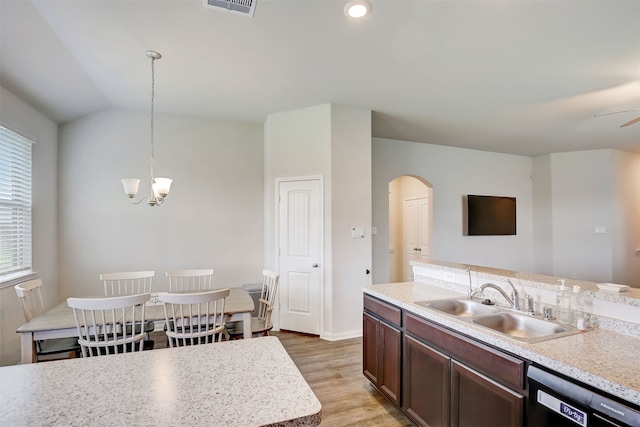 kitchen with black dishwasher, sink, hanging light fixtures, light hardwood / wood-style floors, and lofted ceiling