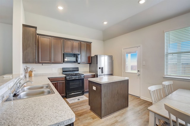 kitchen featuring light hardwood / wood-style flooring, sink, black appliances, dark brown cabinetry, and a center island