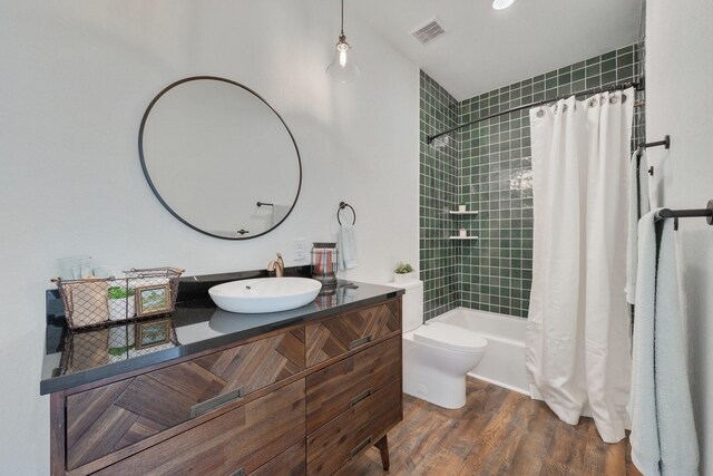 full bathroom featuring wood-type flooring, toilet, vanity, and shower / bath combo