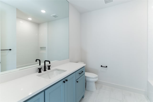 bathroom featuring toilet, vanity, and a tile shower