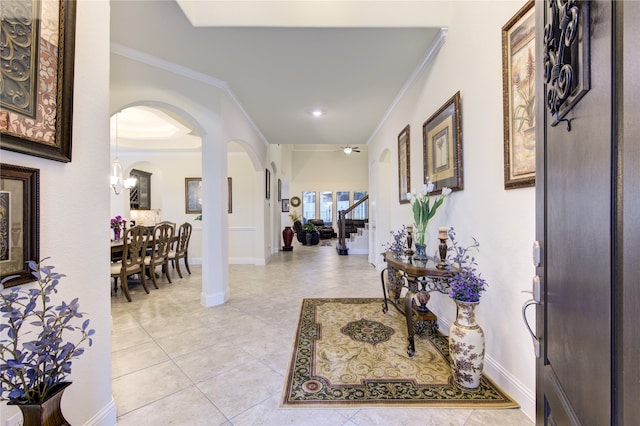 foyer entrance featuring light tile patterned flooring and crown molding