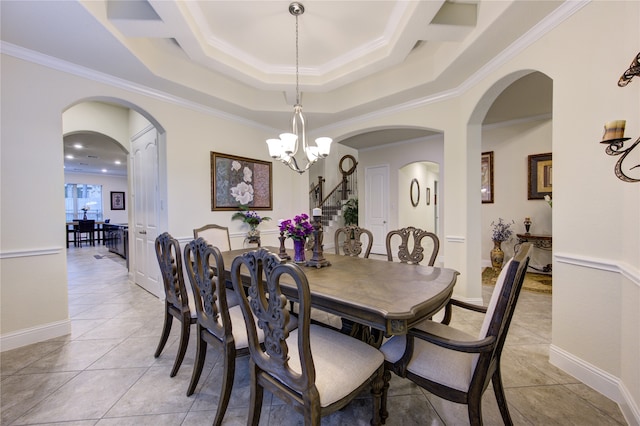 tiled dining area featuring an inviting chandelier, a raised ceiling, and crown molding