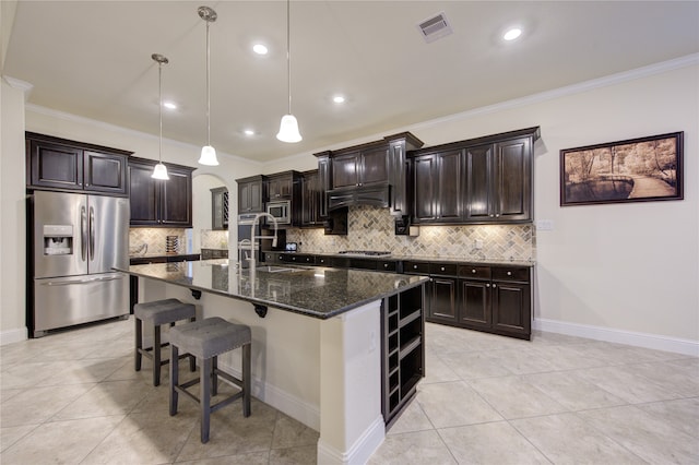 kitchen with crown molding, stainless steel appliances, backsplash, pendant lighting, and an island with sink