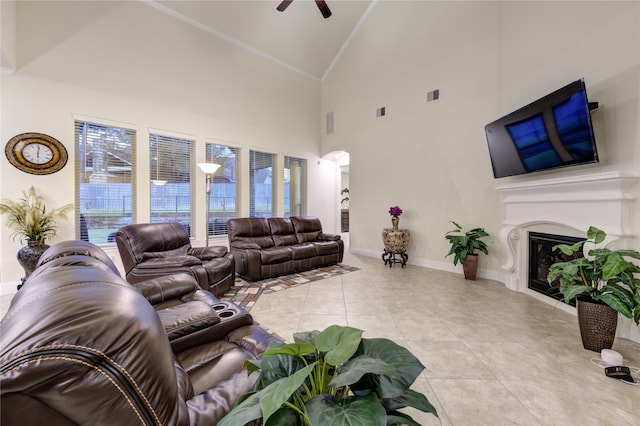 tiled living room with ceiling fan and high vaulted ceiling