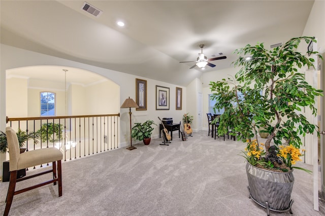 sitting room with carpet flooring, ornamental molding, lofted ceiling, and ceiling fan