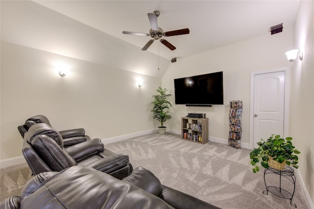 carpeted living room with ceiling fan and vaulted ceiling