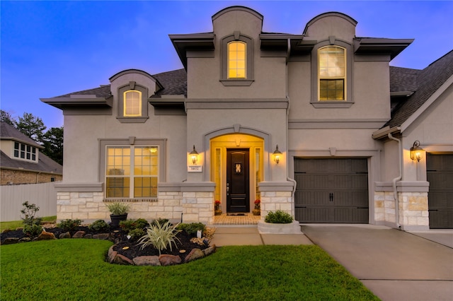 french provincial home with a garage and a yard