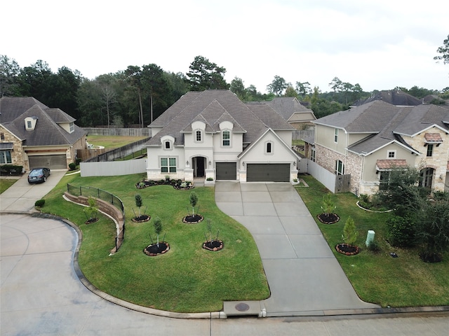 french country home featuring a garage and a front lawn