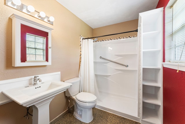 bathroom featuring toilet and curtained shower