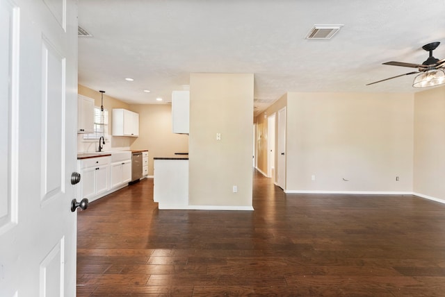 unfurnished living room with sink, dark hardwood / wood-style floors, and ceiling fan