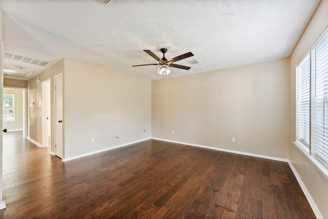 spare room with a textured ceiling, dark hardwood / wood-style floors, and ceiling fan