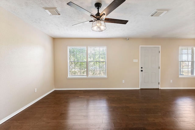 empty room with dark wood-type flooring, a textured ceiling, and ceiling fan