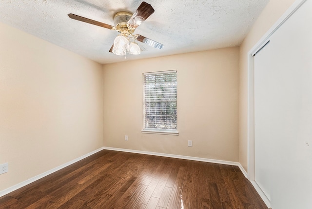 spare room with ceiling fan, a textured ceiling, and dark hardwood / wood-style flooring