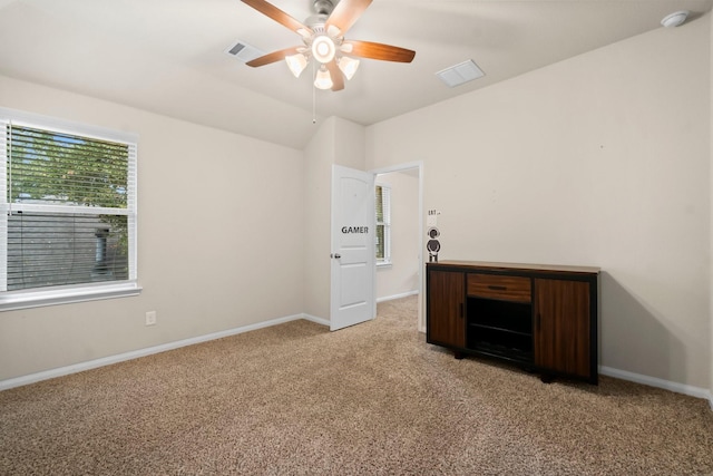 unfurnished bedroom featuring light carpet, vaulted ceiling, and ceiling fan