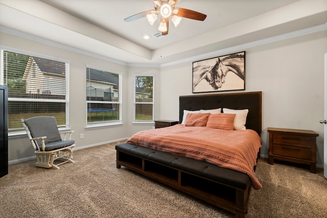 carpeted bedroom with a raised ceiling, ceiling fan, and crown molding