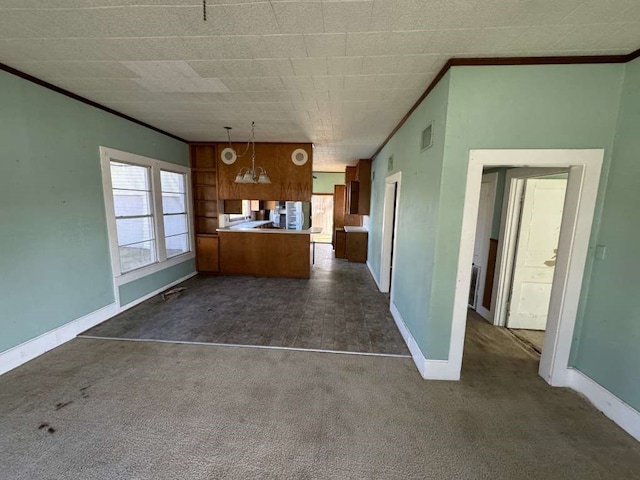 kitchen with dark colored carpet, kitchen peninsula, and pendant lighting