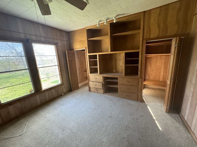 unfurnished bedroom featuring light carpet, ceiling fan, and rail lighting