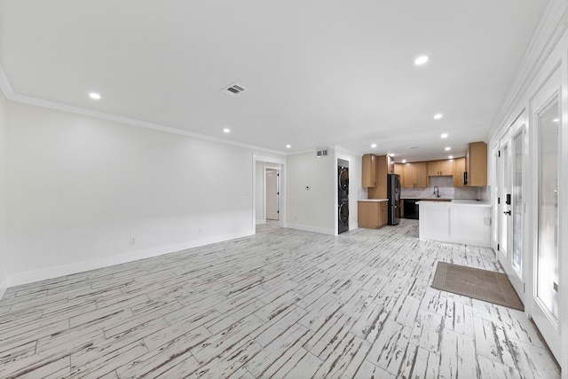 unfurnished living room with ornamental molding, sink, and light wood-type flooring