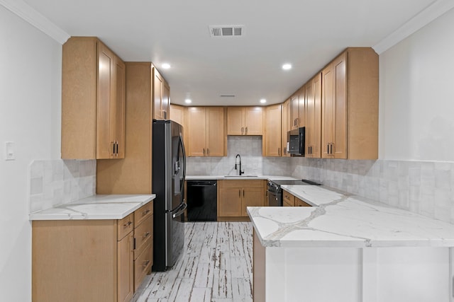 kitchen featuring kitchen peninsula, light stone countertops, ornamental molding, sink, and stainless steel appliances