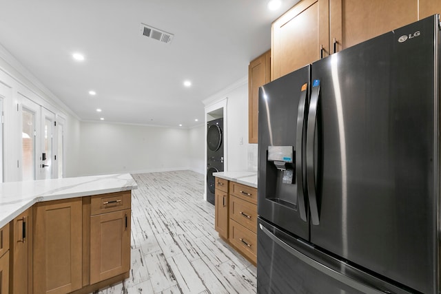 kitchen with light stone countertops, ornamental molding, stainless steel fridge with ice dispenser, and light hardwood / wood-style flooring