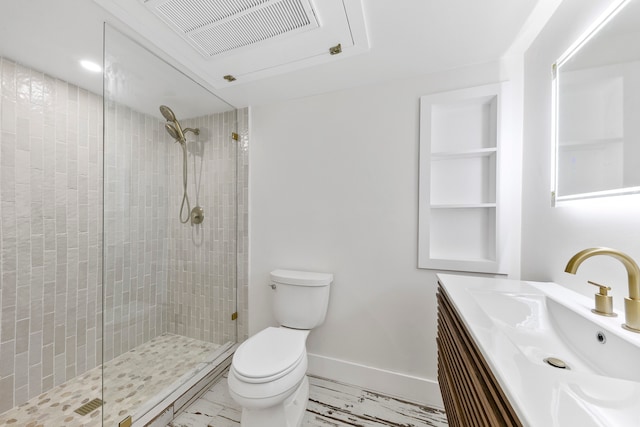 bathroom featuring vanity, toilet, and a shower with shower door