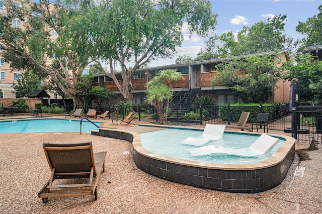 view of swimming pool with a patio area and a jacuzzi