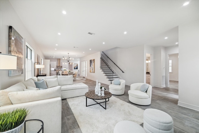 living room with a chandelier, light hardwood / wood-style flooring, and a healthy amount of sunlight