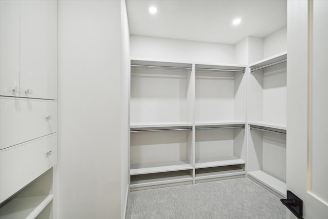 walk in closet with light carpet