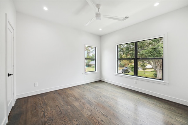 spare room with ceiling fan, a healthy amount of sunlight, and dark hardwood / wood-style flooring