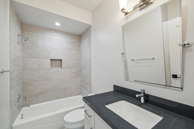 full bathroom with vanity, tiled shower / bath combo, and toilet