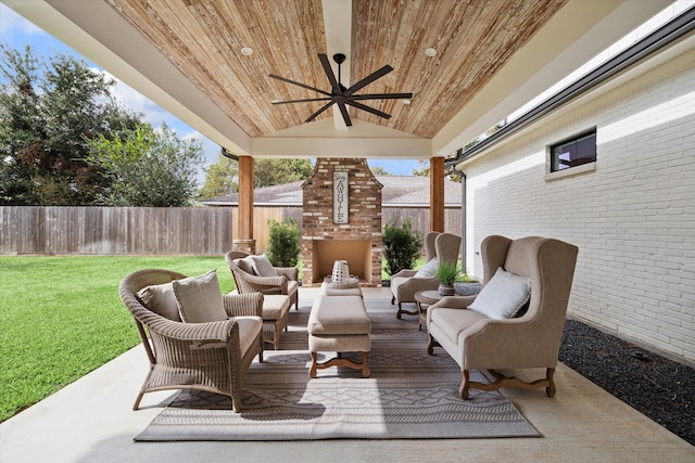 view of patio / terrace with ceiling fan and an outdoor living space with a fireplace