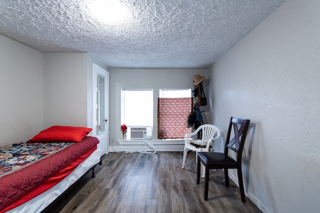 bedroom featuring a textured ceiling, dark hardwood / wood-style flooring, and cooling unit