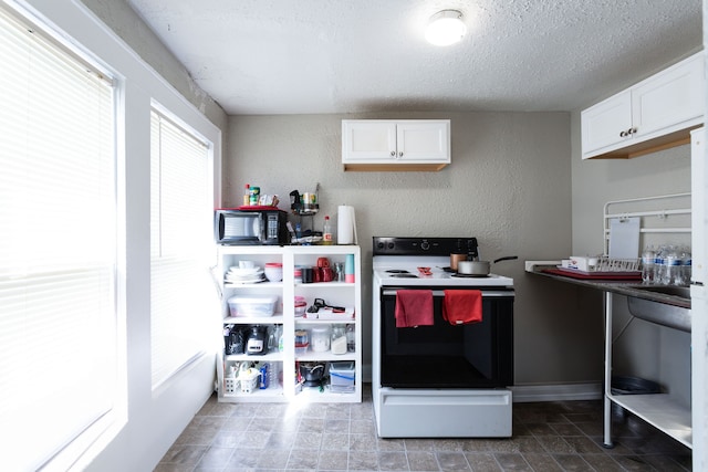 kitchen with white cabinetry, a textured ceiling, and electric stove