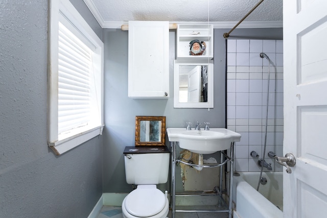 full bathroom with sink, a textured ceiling, ornamental molding, toilet, and tiled shower / bath combo