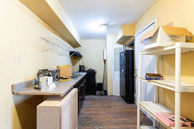 kitchen featuring dark hardwood / wood-style floors and black refrigerator